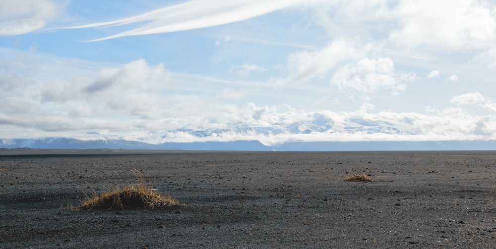 a large open field with mountains in the distance