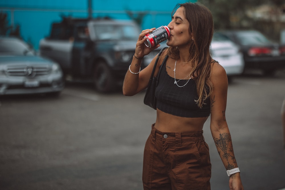a woman in a crop top drinking a soda