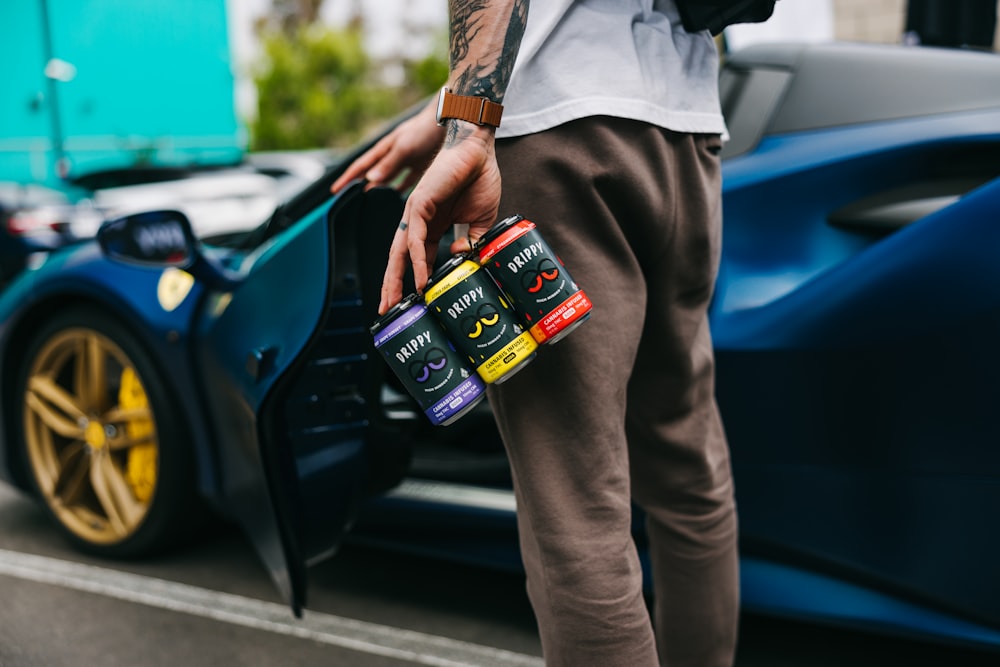 a man standing next to a blue sports car