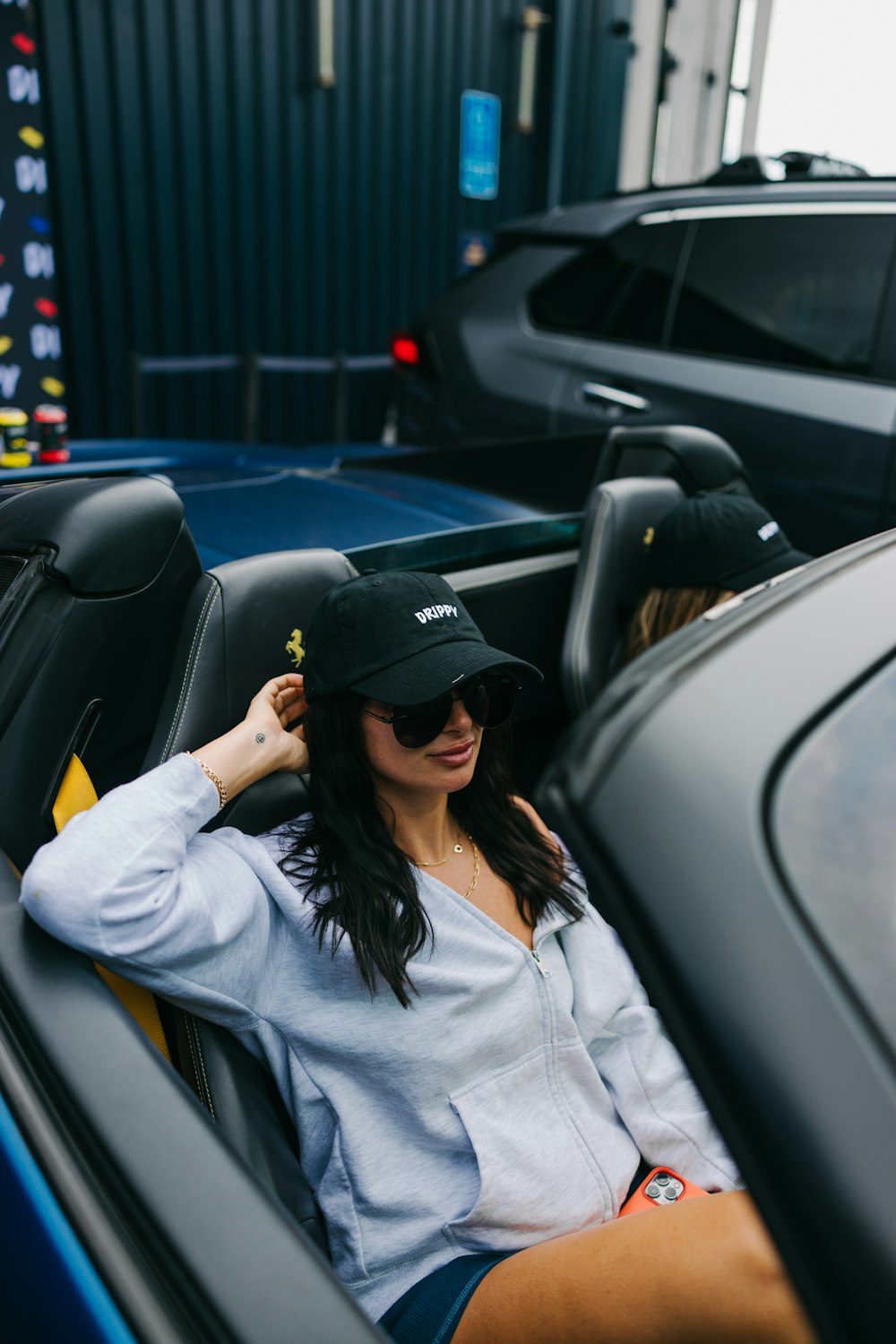 a woman sitting in the back of a blue car