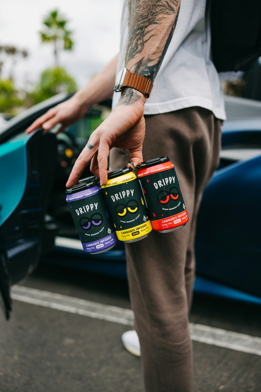 a man holding three cans of beer in his hand