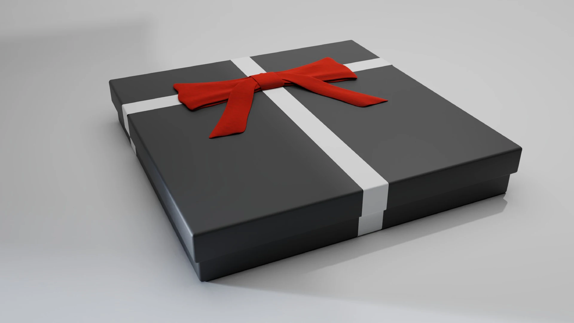 A black rigid gift box tied with a red ribbon