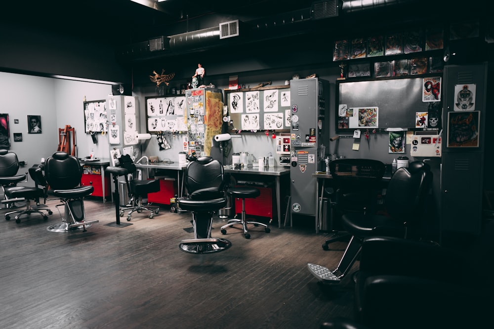 uma barbearia com cadeiras e quadros na parede