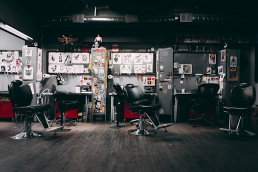a barber shop with chairs and posters on the wall