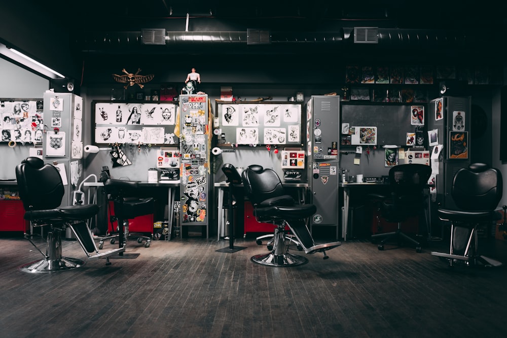uma barbearia com cadeiras e cartazes na parede