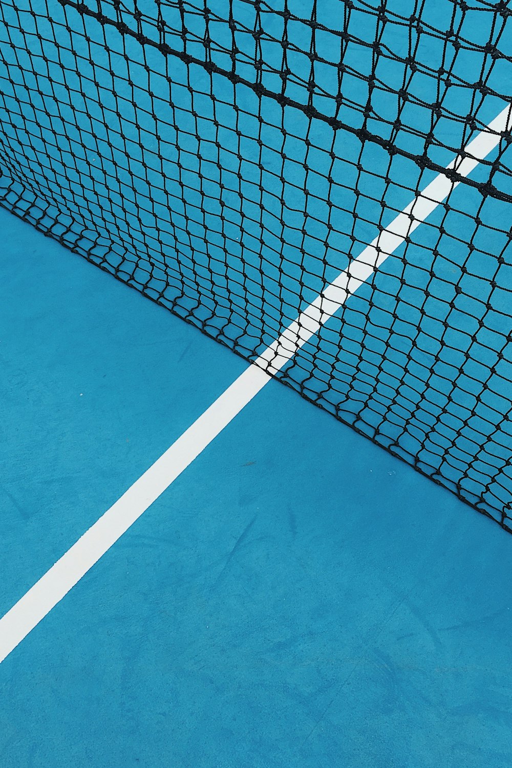 a blue tennis court with a white line on it