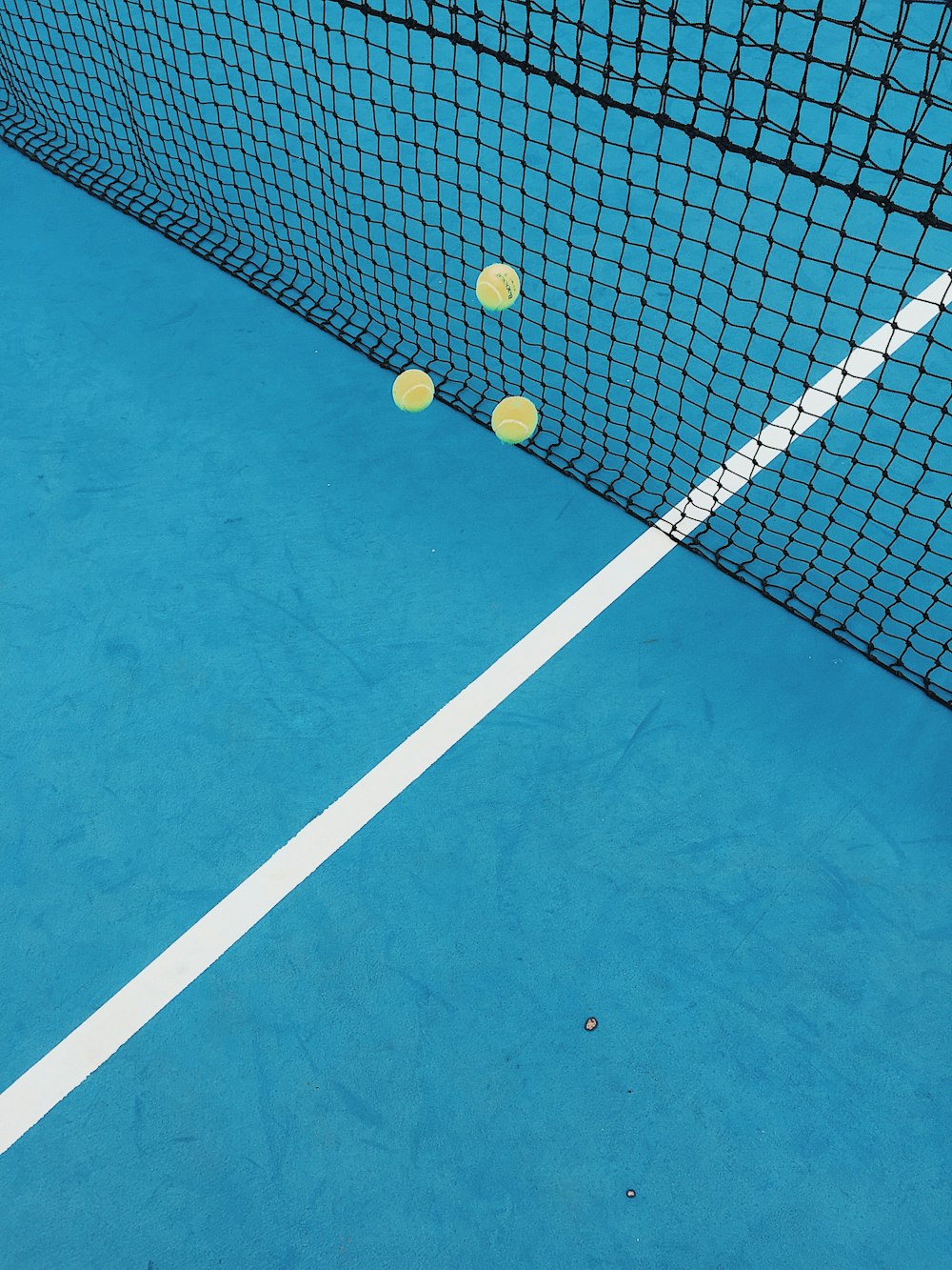 a tennis court with three tennis balls on it