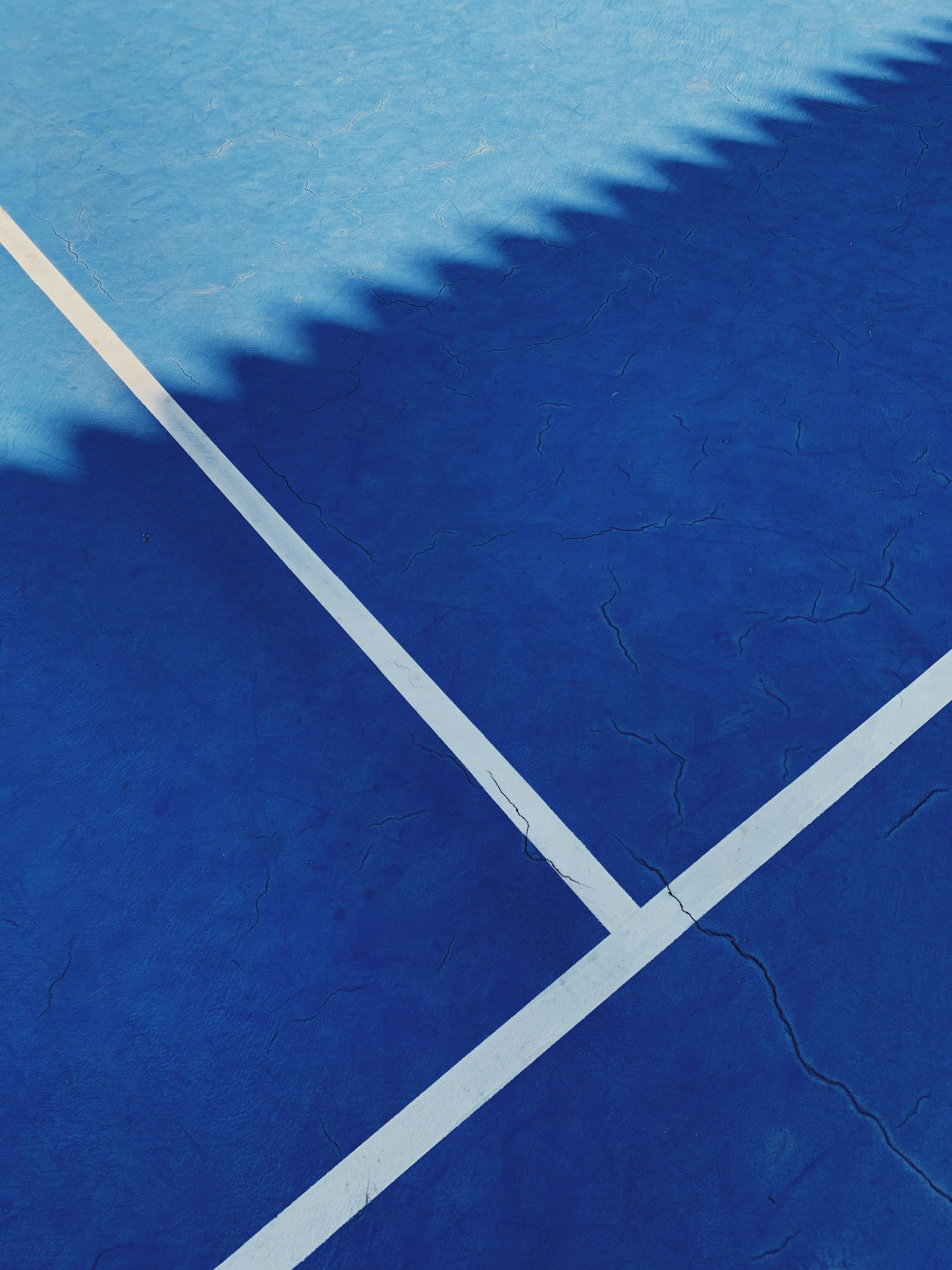 a shadow of a tennis player on a tennis court