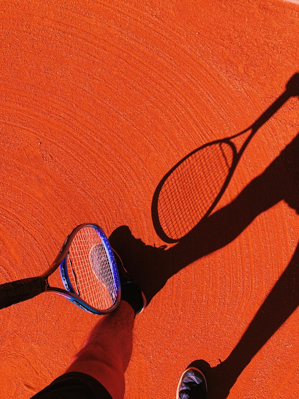 uma sombra de uma pessoa segurando uma raquete de tênis