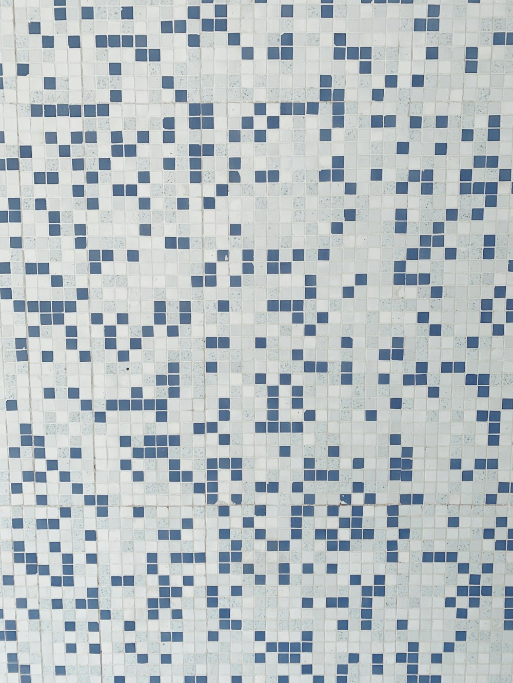 una pared de azulejos blancos y azules con cuadrados azules