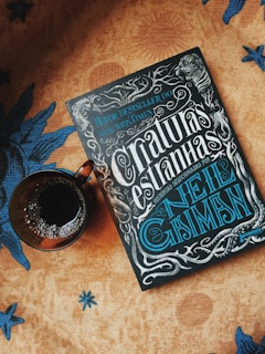 Close-up of the elegant cover of After the Storm, placed on a wooden table next to a steaming cup of coffee and a vintage pen.
