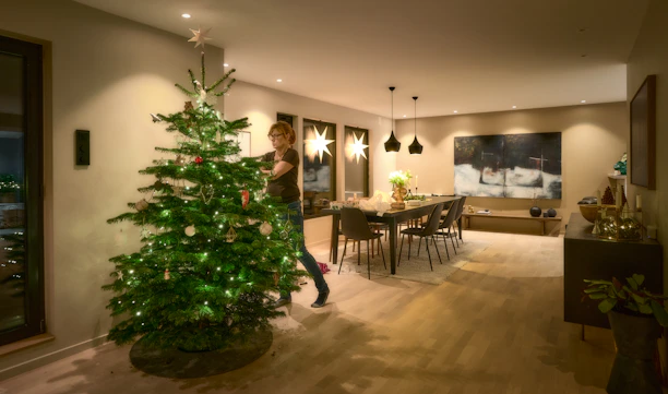 A skilled electrician installing modern lighting fixtures in a cozy living room.