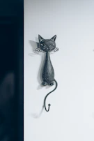 A minimalist wall-mounted cat shelf in matte black finish, perfect for urban apartments with limited space.