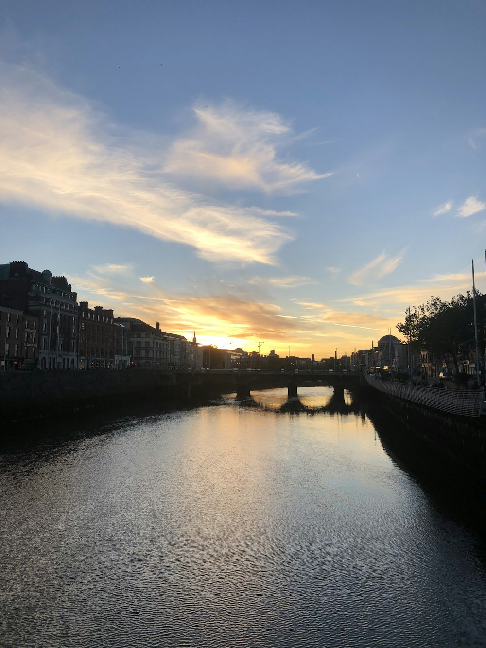 a body of water with a bridge in the background