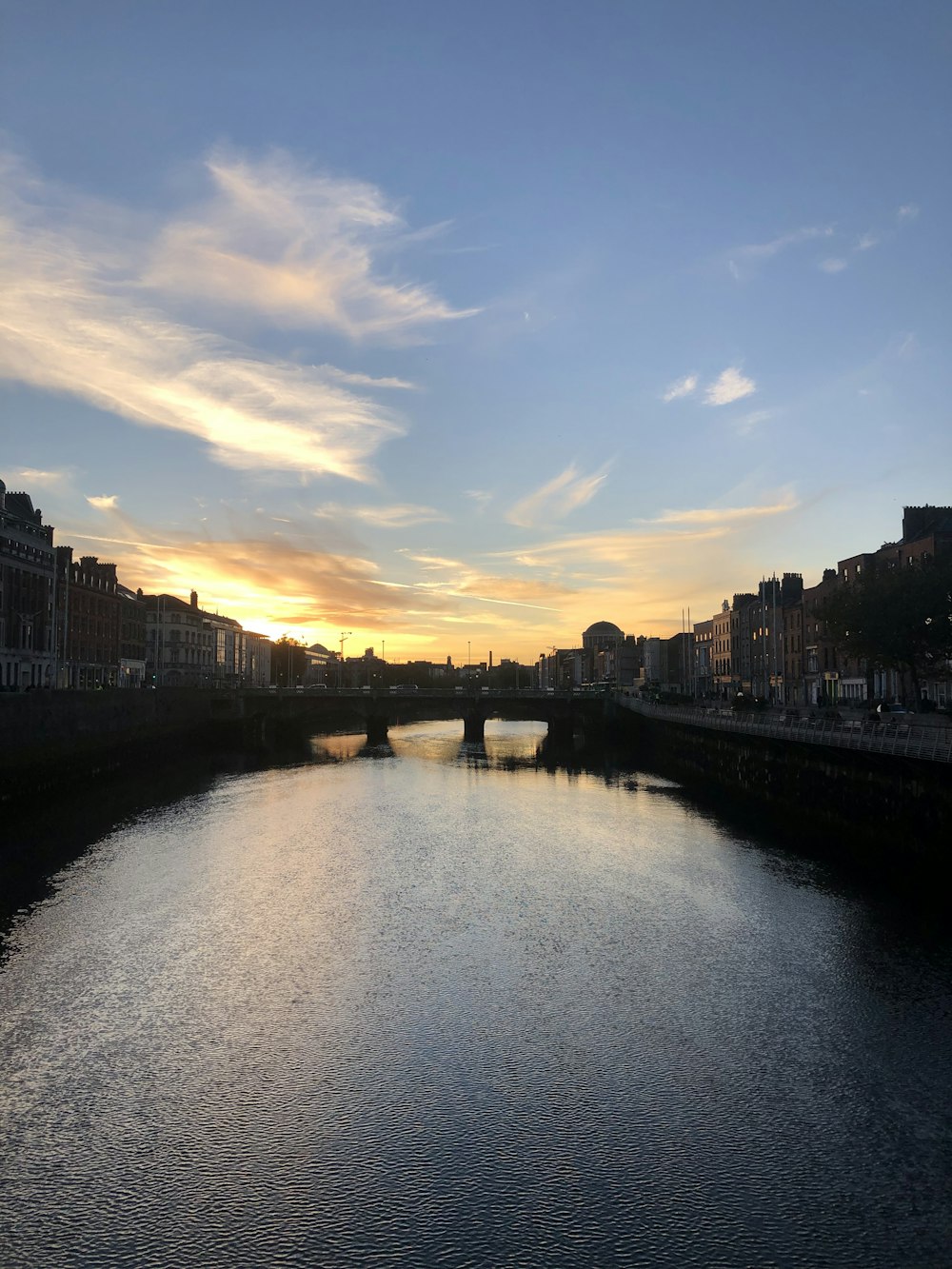 a body of water with a bridge in the background