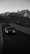 Dynamic shot of an automotive influencer filming a luxury car on a winding mountain road.