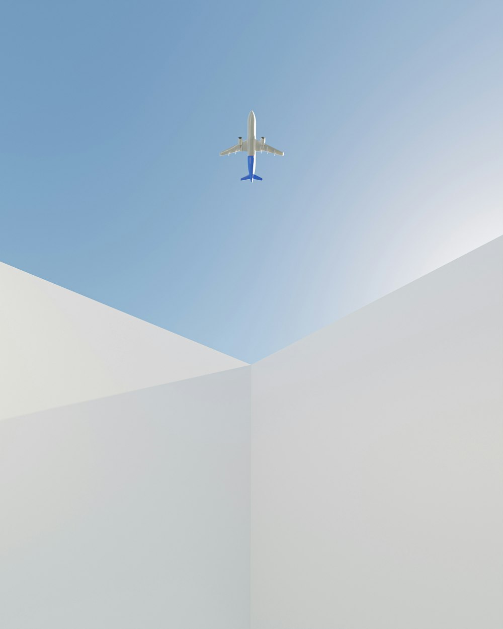 an airplane is flying over a white wall