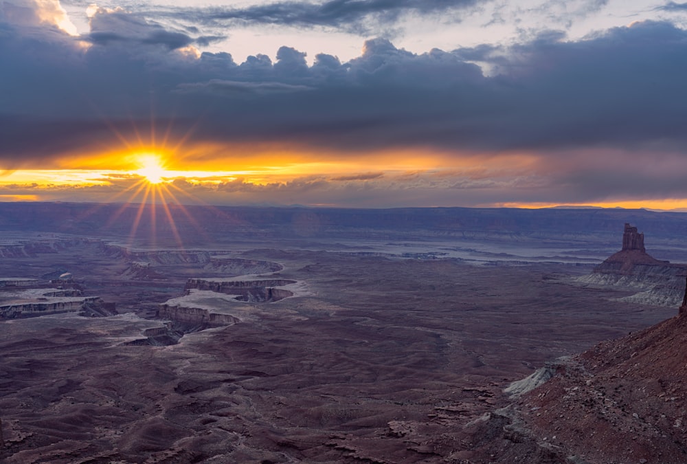 the sun is setting over the desert landscape