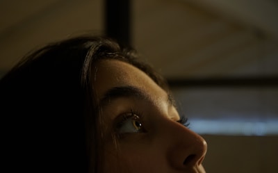 Soft-lit close-up of a client's perfectly sculpted lashes with a warm ivory background.