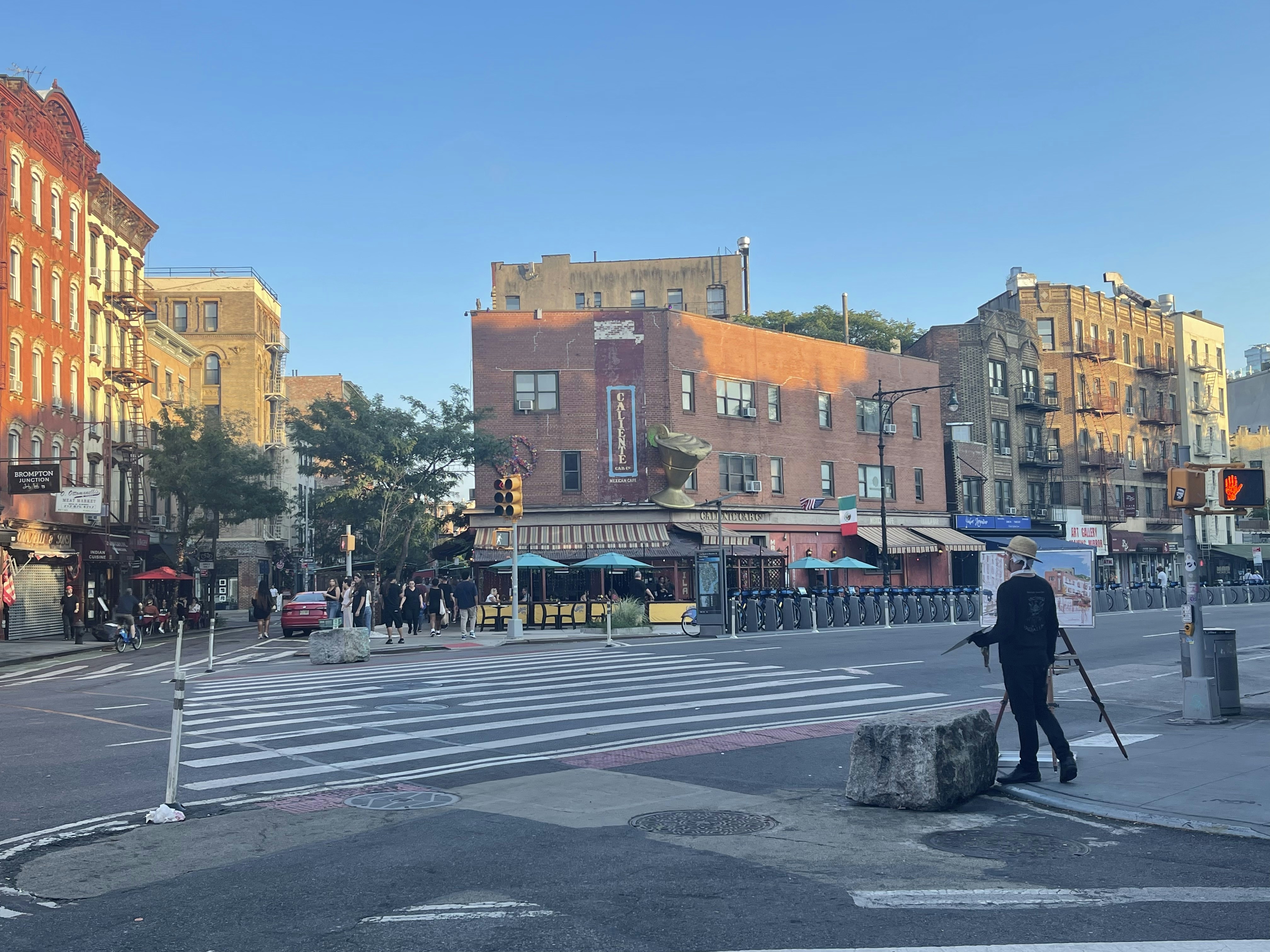 Un hombre parado al costado de una carretera junto a un cruce de peatones