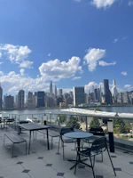 Spacious outdoor terrace with city skyline view at sunset.