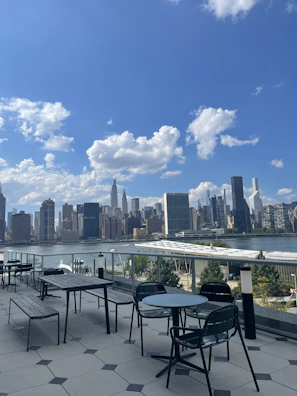 Spacious outdoor terrace with city skyline view at sunset.