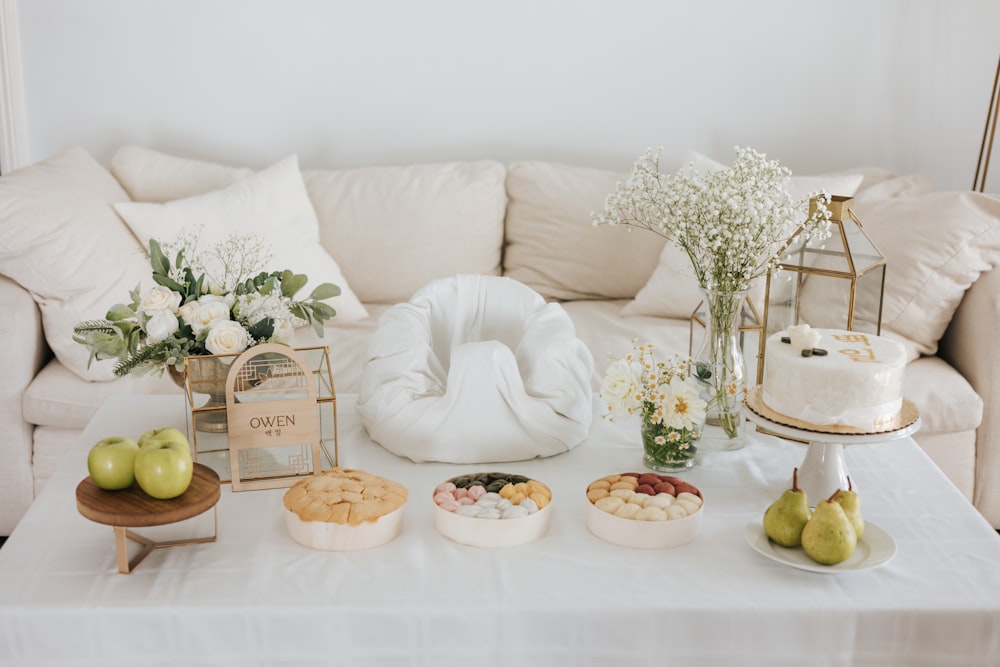 a table topped with a white couch covered in food