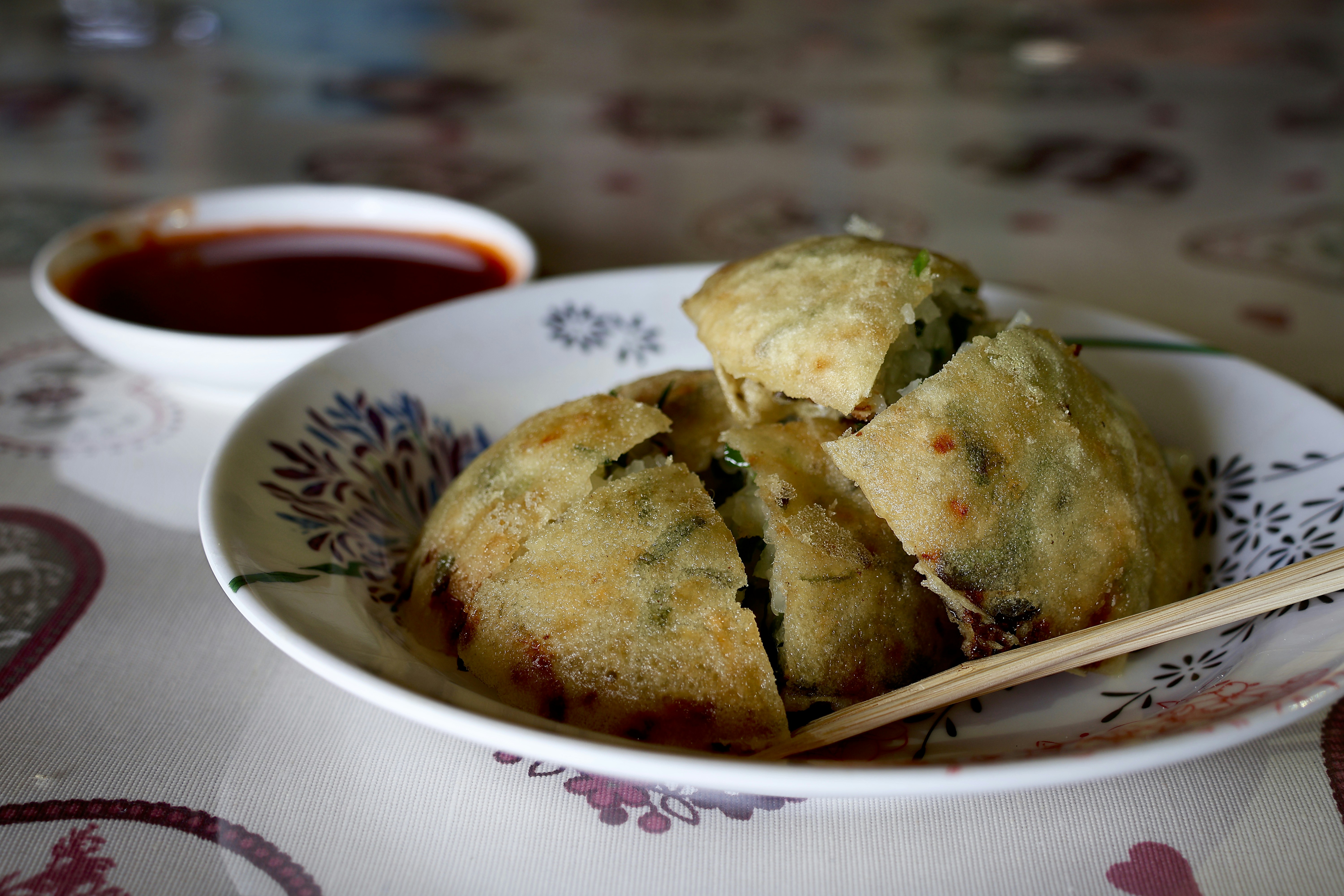 a bowl of food with chopsticks on a table