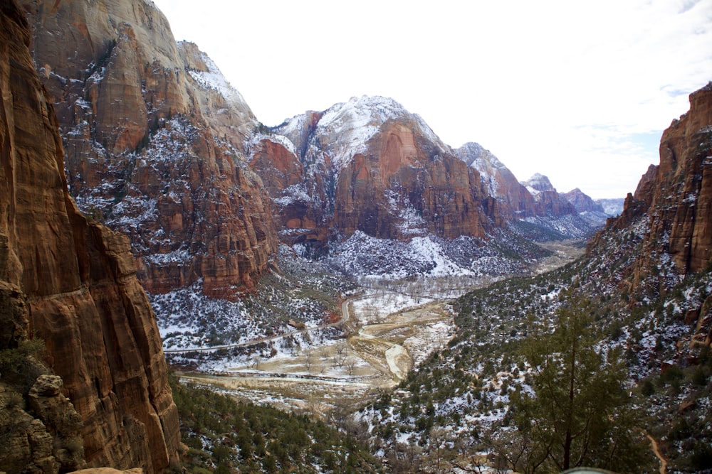 a view of a valley with snow on the mountains