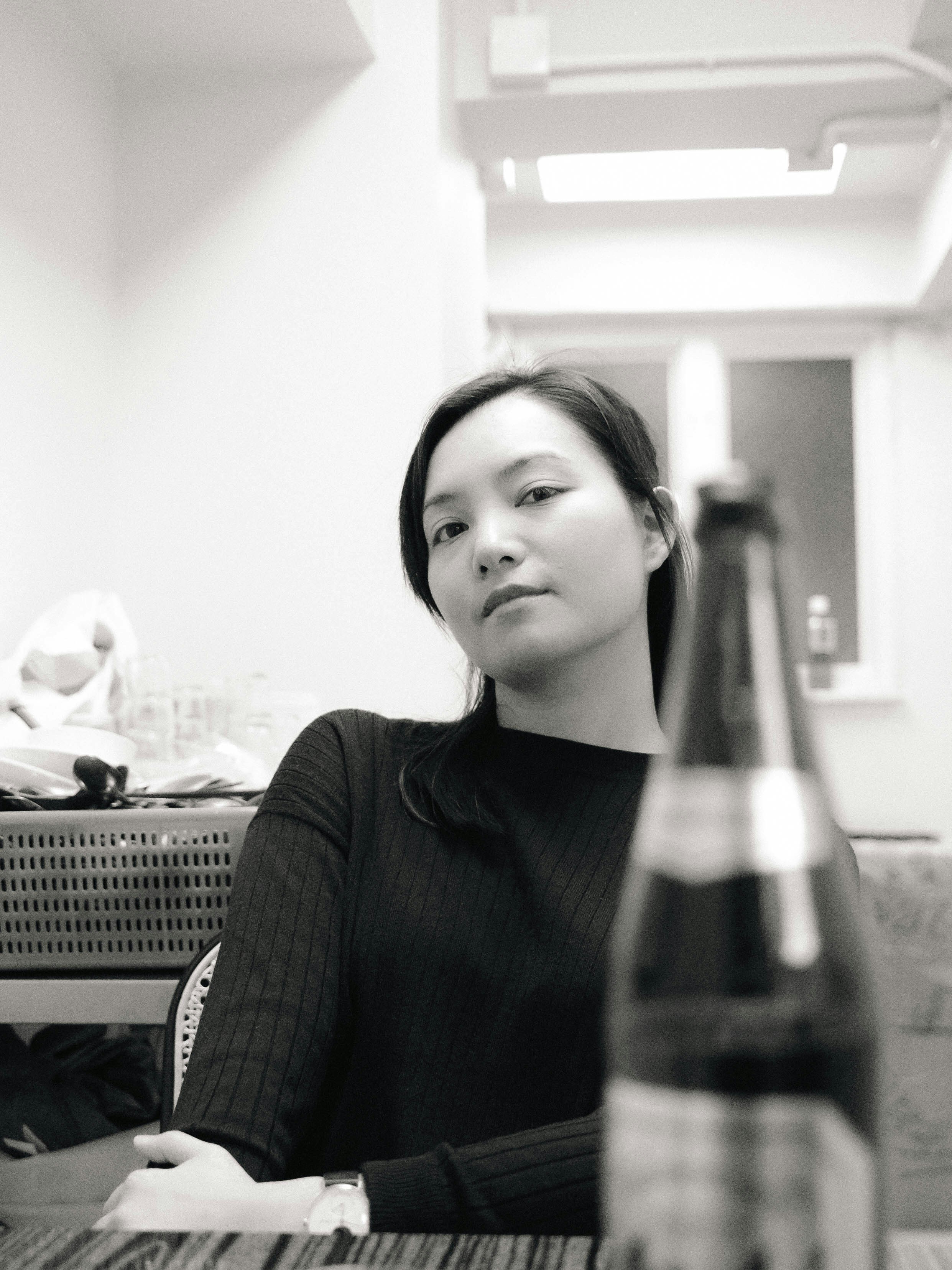 ビール瓶を持ってテーブルに座っている女性