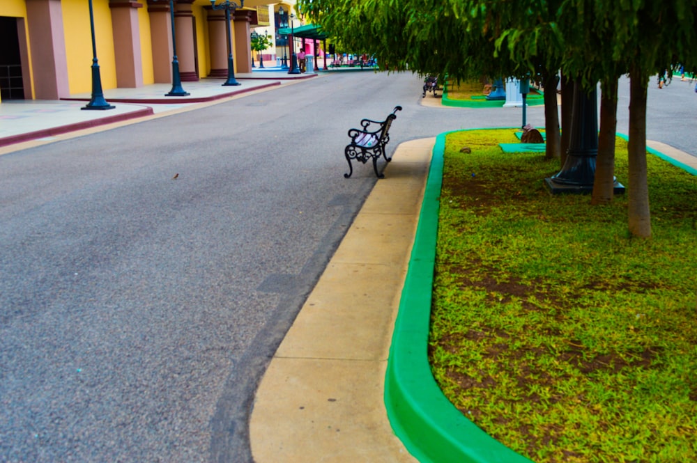 a park bench sitting on the side of a road