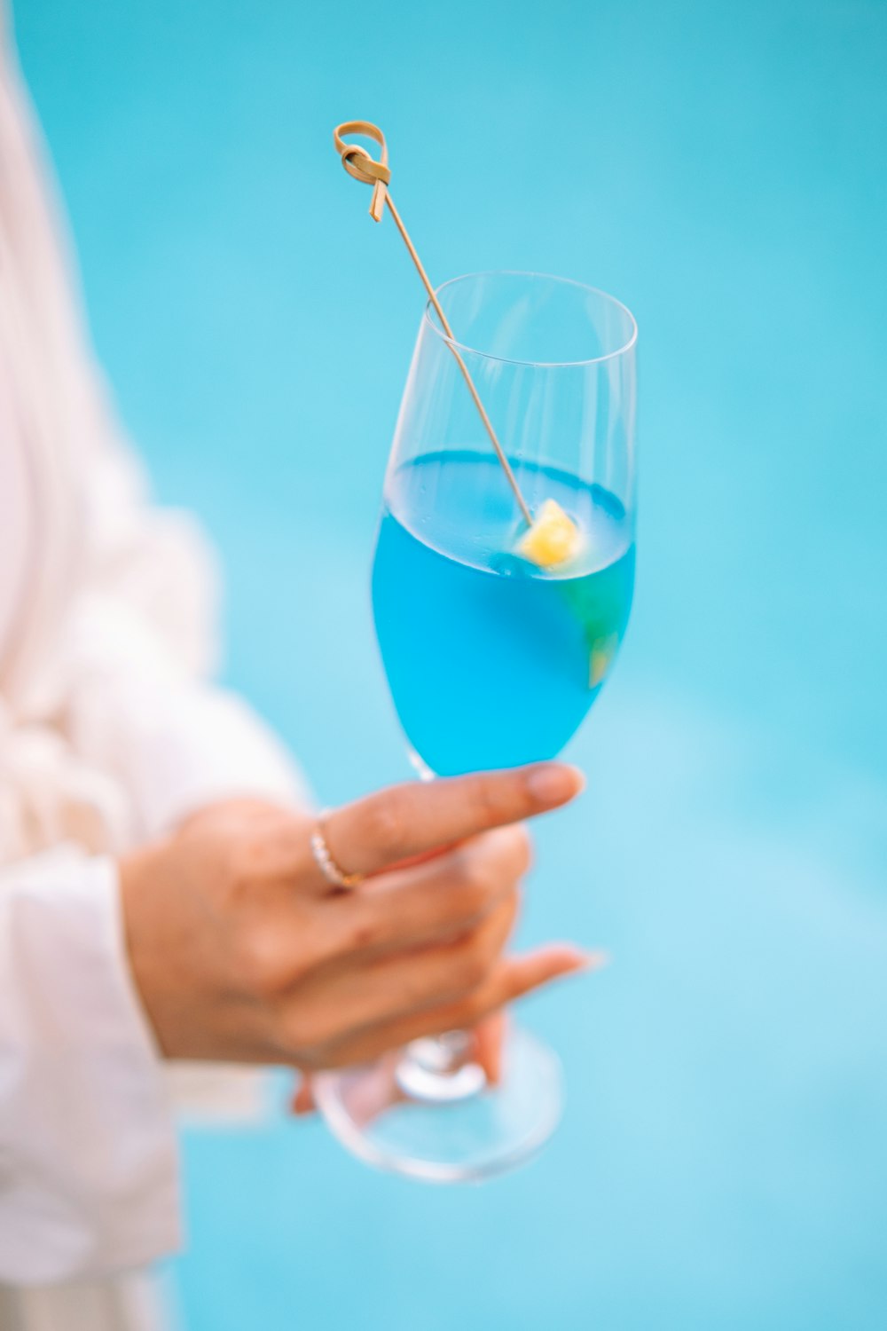 a person holding a blue drink in their hand