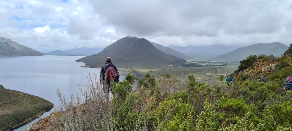 a man standing on top of a lush green hillside