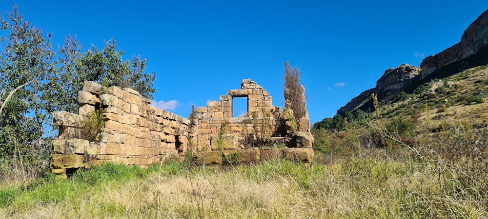 the ruins of a building in the middle of a field