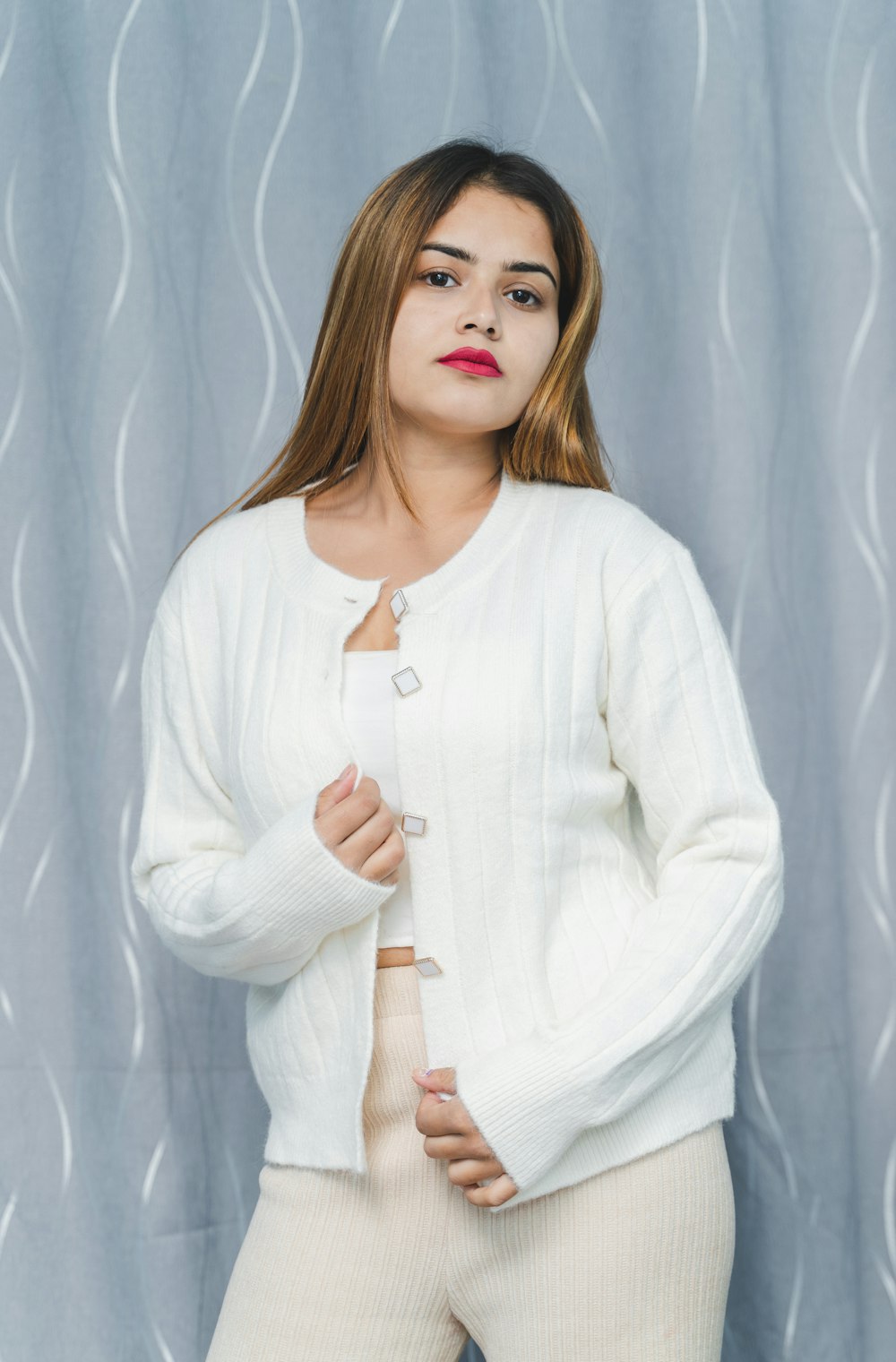 a woman posing for a picture in a white sweater