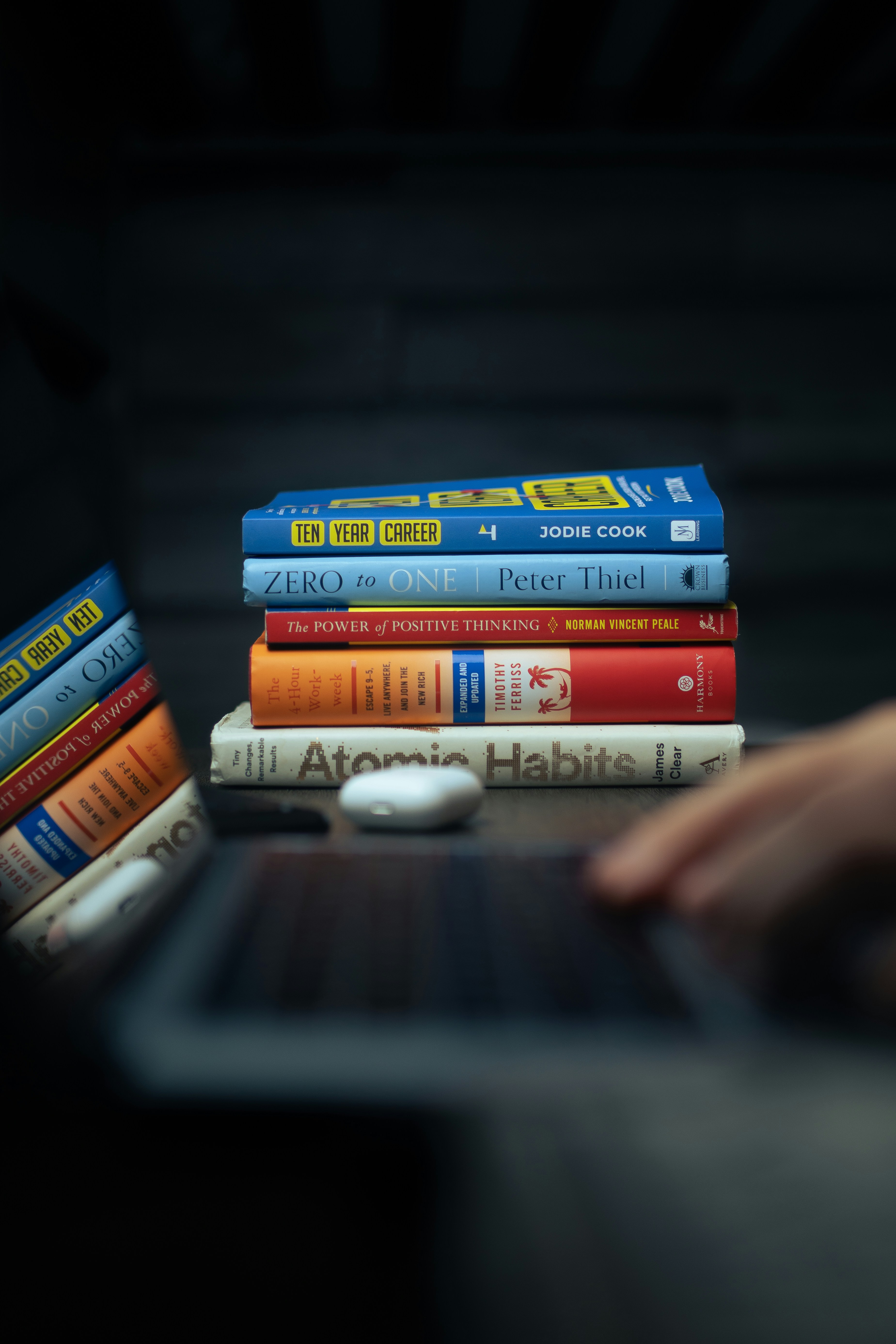 setumpuk buku yang duduk di atas komputer laptop