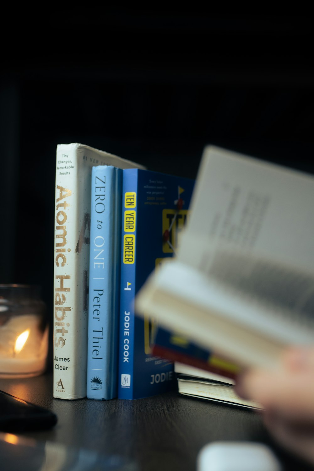 a table topped with books and a candle