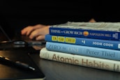 a stack of books sitting on top of a wooden table
