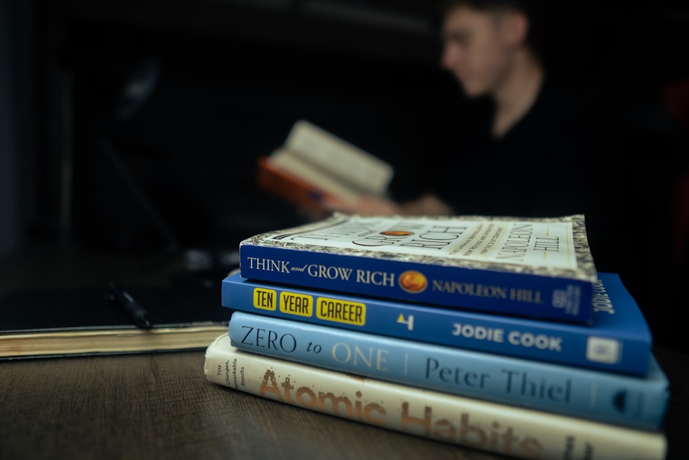 a stack of books sitting on top of a wooden table