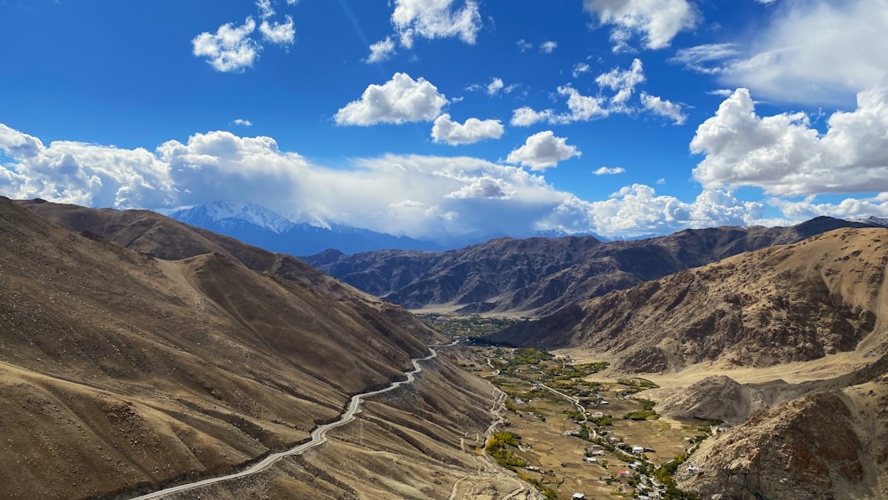 a scenic view of a valley with mountains in the background