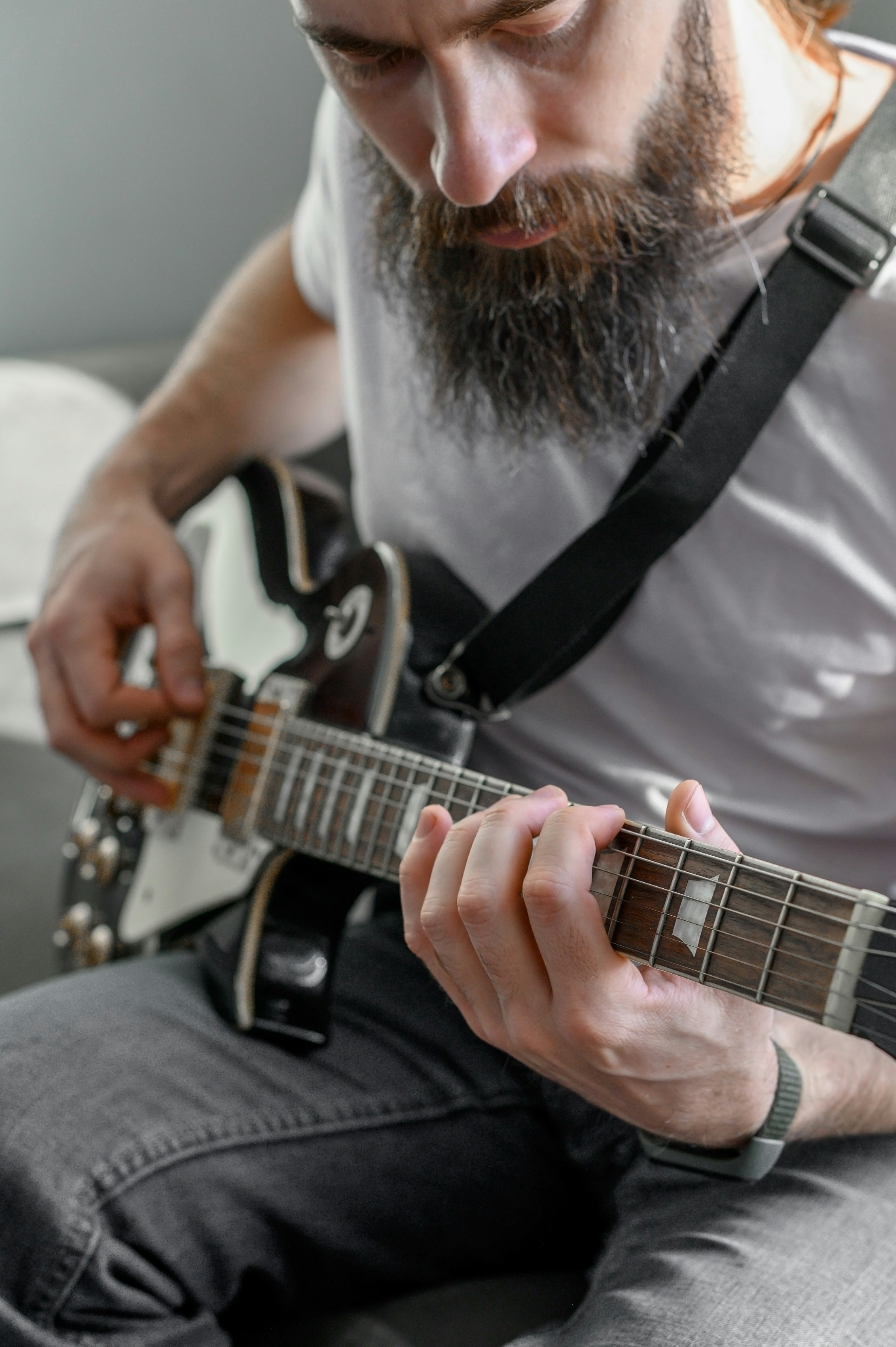 Un hombre con barba tocando una guitarra