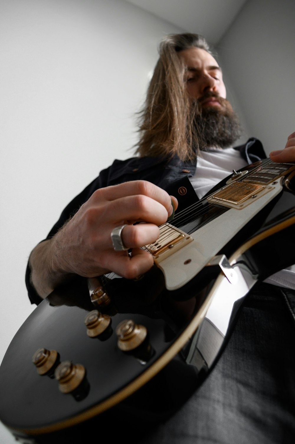 a man with long hair playing a guitar