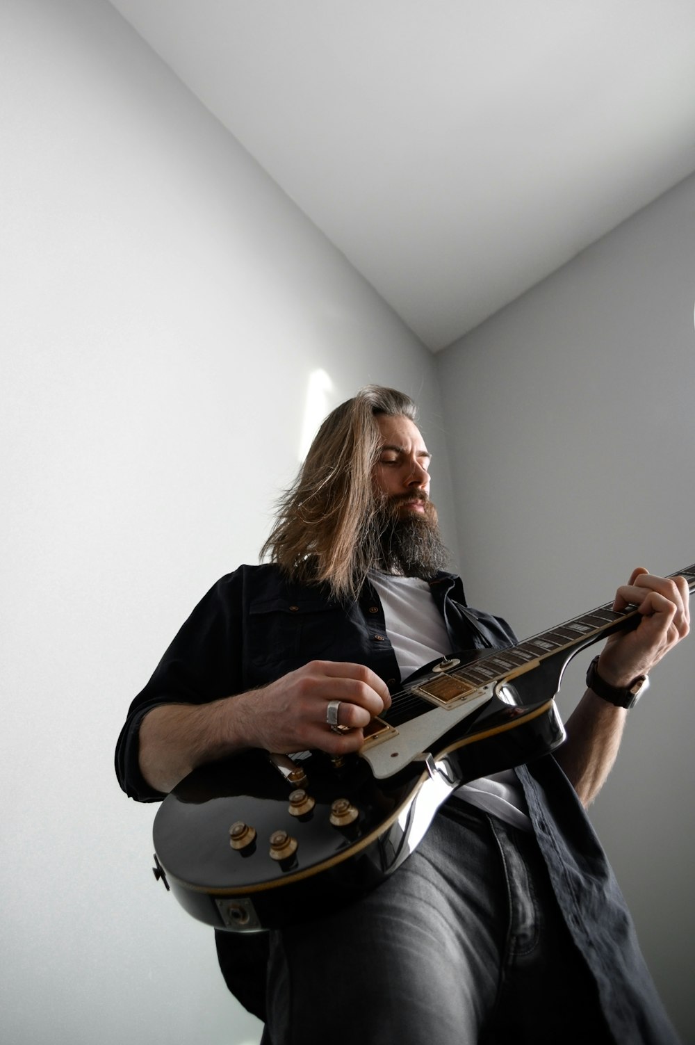 a man with long hair playing a guitar