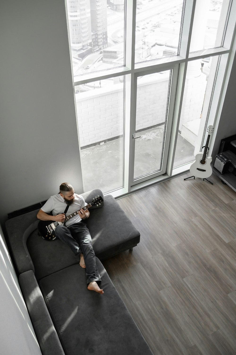 a man sitting on a couch playing a guitar