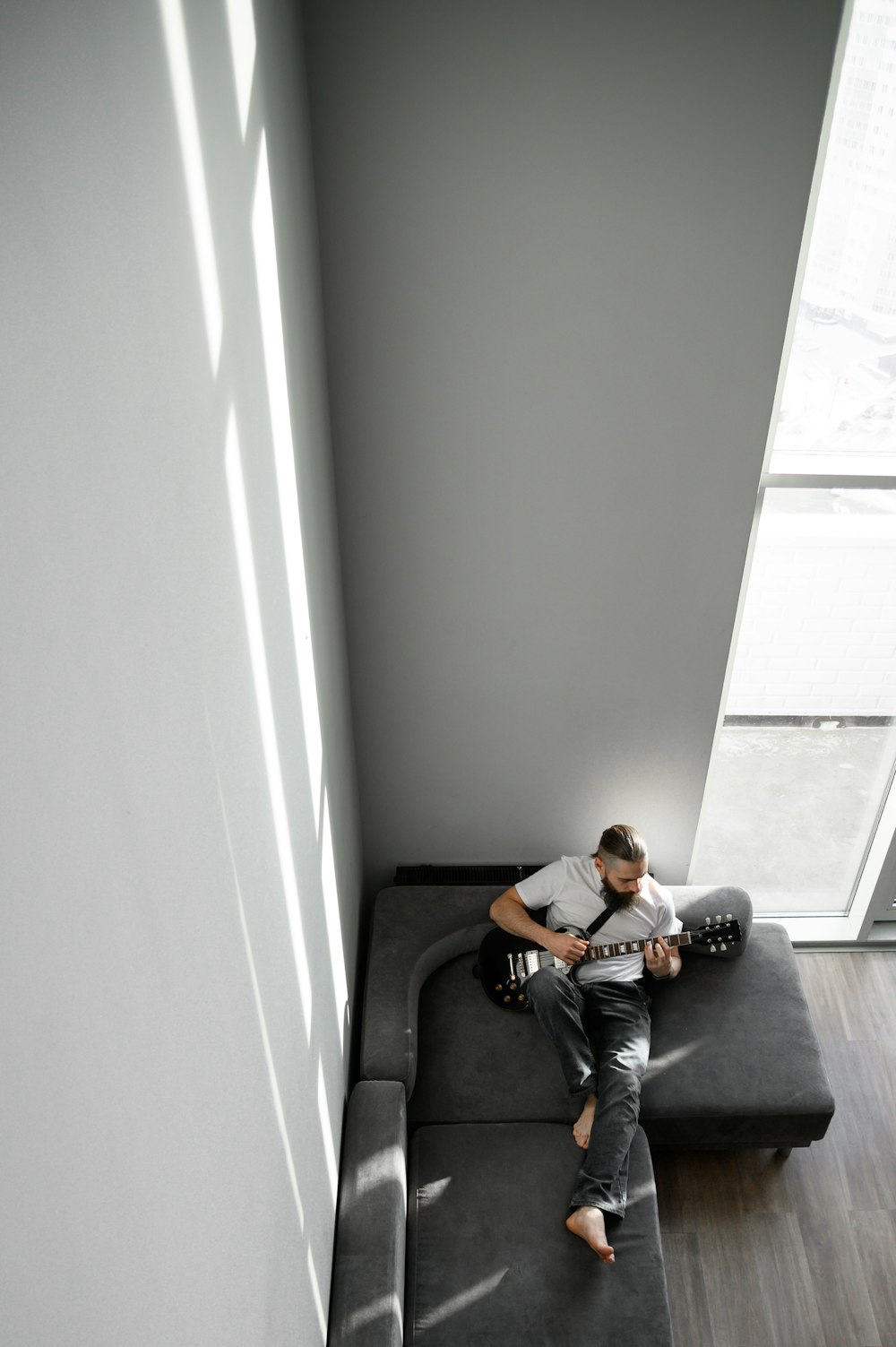 a man sitting on a couch playing a guitar