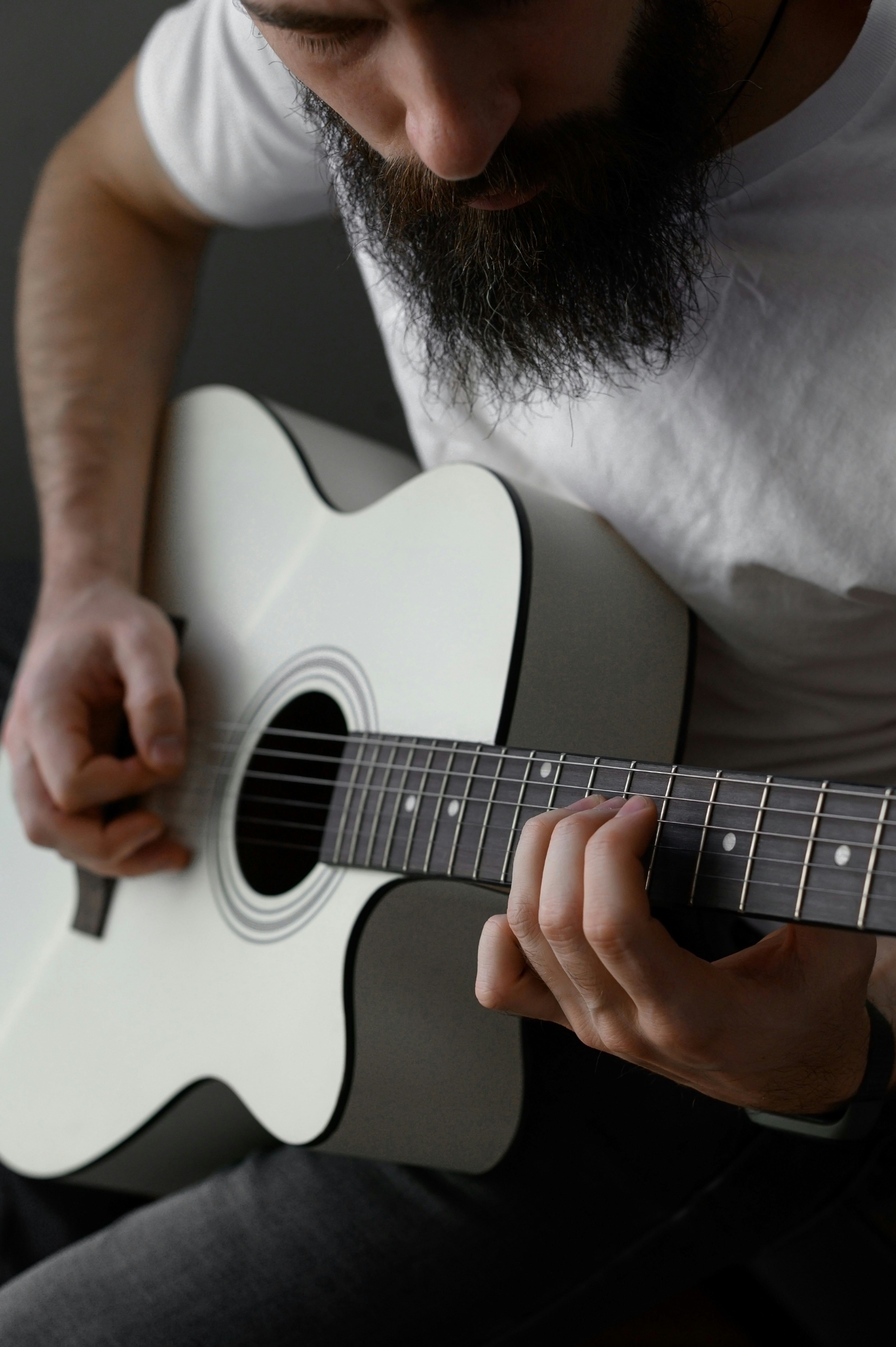 Un hombre con barba tocando una guitarra