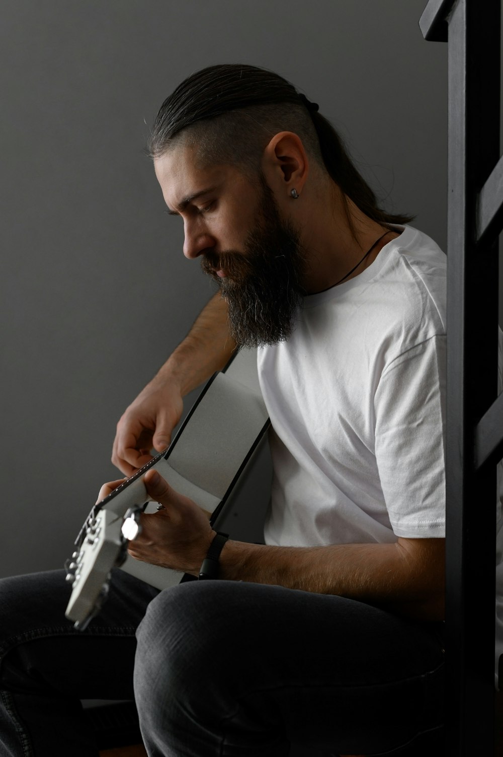 a man with a beard sitting down holding a cell phone