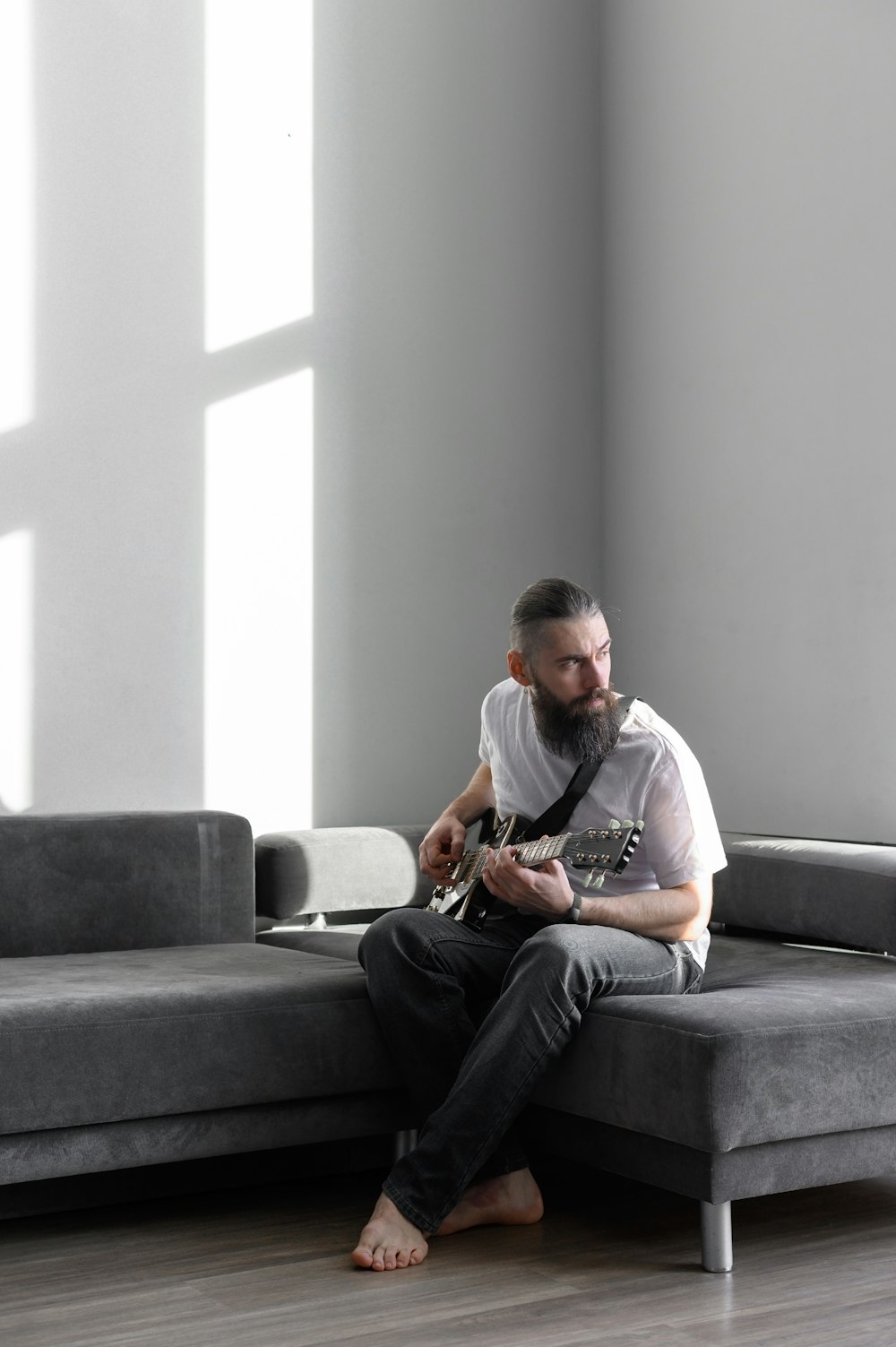 a man sitting on a couch playing a guitar