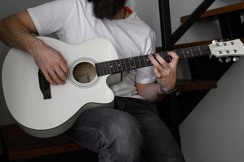 a man with a beard playing a guitar