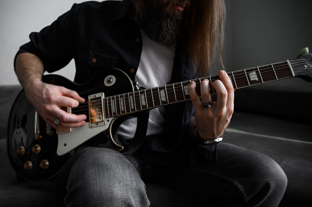 a man sitting on a couch playing a guitar